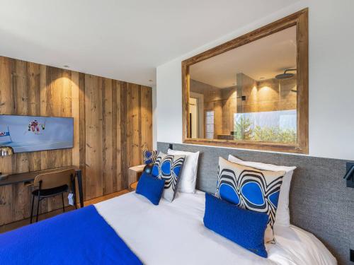 a bedroom with a large bed with blue pillows at Appartement Courchevel 1850, 4 pièces, 6 personnes - FR-1-564-91 in Courchevel