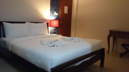 a bedroom with a large white bed with towels on it at Chatchada House in Ao Nang Beach