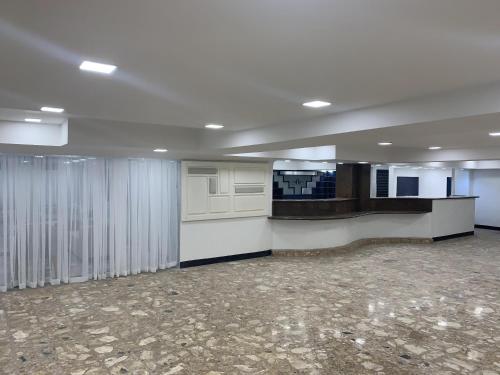 ein leeres Büro mit einem großen Zimmer mit weißen Wänden in der Unterkunft HOTEL PRINCESA PLAZA in Maracay