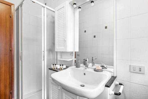 a white bathroom with a sink and a shower at Residence Fragole Apartment Venice in Campalto