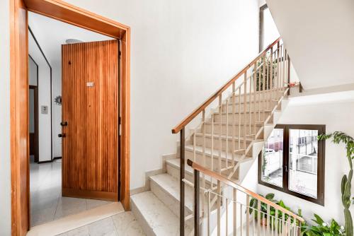 a hallway with stairs and a wooden door at Residence Fragole Apartment Venice in Campalto