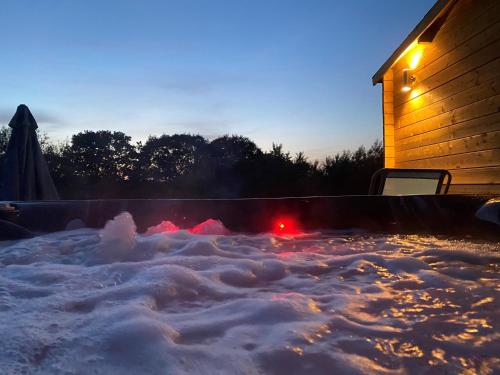 Silver Springs Farm Lodge في Dingestow: كومة من الثلج في الفناء الخلفي في الليل