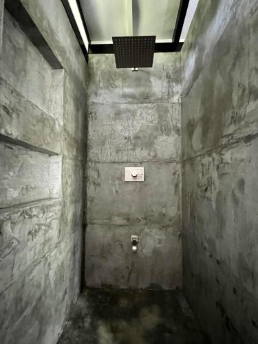 a dark room with a stone wall and a light at Whispering Wisdom in Cahuita