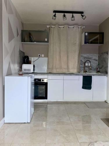 une cuisine avec des armoires blanches et un évier dans l'établissement Love room #BBSH, à Goussainville