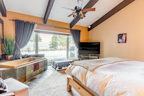 um quarto com uma cama, uma banheira e uma televisão em Flathead Lake Villa - Main Home em Lakeside