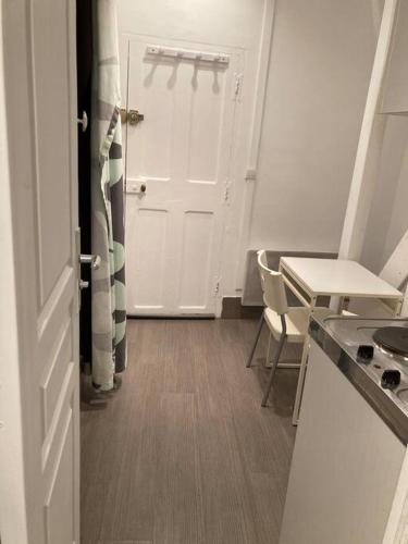 une cuisine avec une porte blanche, une table et des chaises dans l'établissement Appartement T1 Avignon centre, à Avignon
