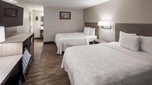 a hotel room with two beds and a flat screen tv at SureStay Hotel by Best Western Findlay in Findlay