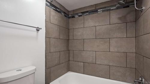 a bathroom with a tiled shower with a toilet at SureStay Hotel by Best Western Findlay in Findlay