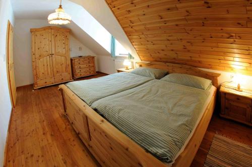 a large bed in a room with a wooden ceiling at Einkehrhof Poggau in Reinsberg