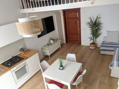 een keuken en een woonkamer met een witte tafel en stoelen bij San Carlo Apartment in Napels