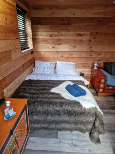 een slaapkamer met een bed in een blokhut bij Gezellige Blokhut op de Veluwe in Emst