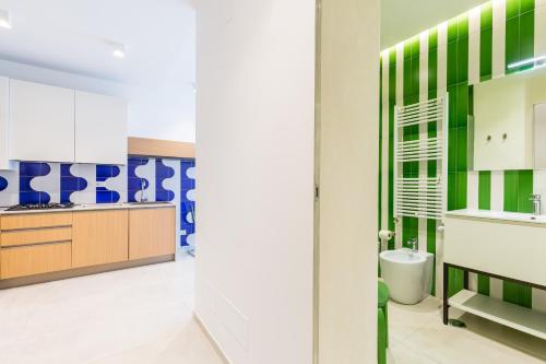ein Badezimmer mit grünen und weißen Schränken und einem Waschbecken in der Unterkunft Starhost - Mazzini Apartments in Salerno