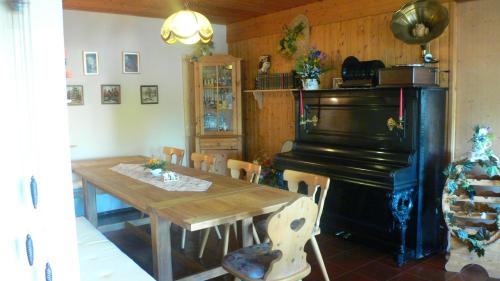 a dining room with a table and a piano at Landhotel Sperlingsberg in Crimmitschau
