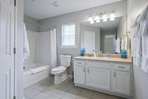 ein Badezimmer mit einem Waschbecken, einem WC und einem Spiegel in der Unterkunft Lots of Hot Spots & Activities Near This Townhome in Cartersville