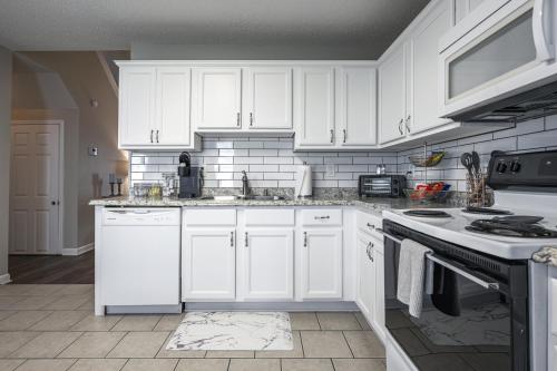 a white kitchen with white cabinets and appliances at Lots of Hot Spots & Activities Near This Townhome in Cartersville