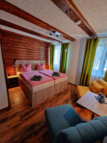 a bedroom with a large bed and a couch at Gästehaus Geist Inkl, Chiemgau Karte in Ruhpolding