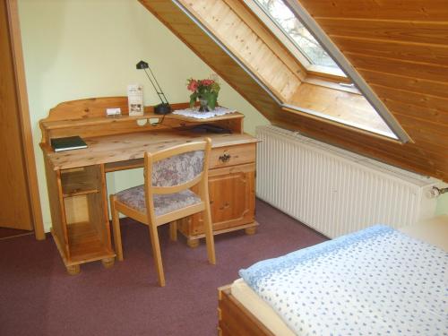 an attic room with a desk and a bed at Landhotel Sperlingsberg in Crimmitschau