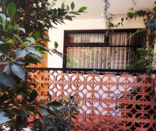 an orange gate with a window with a curtain at Santa Josefita B&B in Cholula