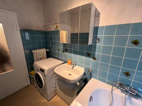 uma casa de banho em azulejos azuis com um lavatório e um WC em Apartment Colonia em Colônia