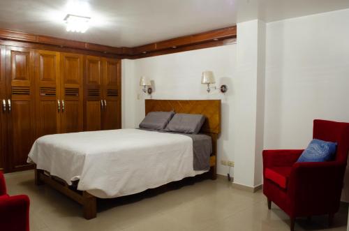 1 dormitorio con 1 cama y 1 silla roja en Irene's House, en Lima