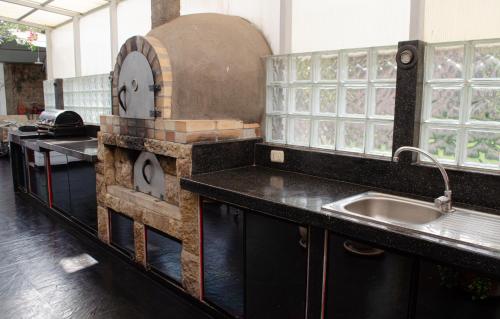 una cocina con fregadero y un reloj en la encimera en Irene's House, en Lima