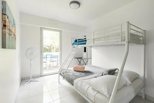 ein weißes Schlafzimmer mit einem Etagenbett mit einer Leiter in der Unterkunft Rooftop pool, private garden, at the sand beach! in Antibes