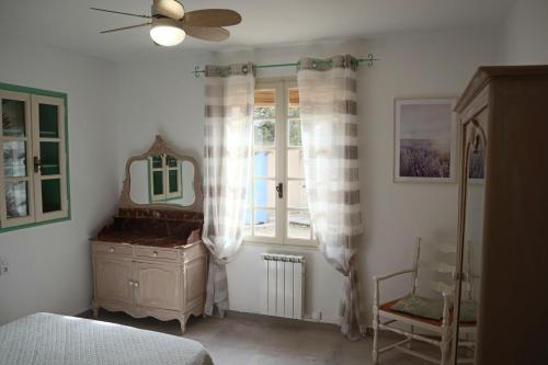 een slaapkamer met een bed, een dressoir en een raam bij L'Arc en Ciel in Gréoux-les-Bains
