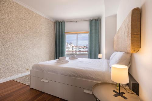 1 dormitorio con 1 cama grande y ventana en Sunny 2 BDR Apartment by LovelyStay en Charneca