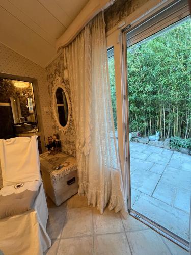 - une chambre avec un lit et une grande porte coulissante en verre dans l'établissement Villa Les Iris, à Sernhac