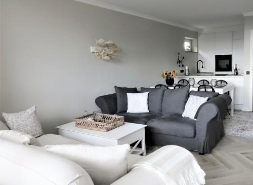 ein Wohnzimmer mit einem Sofa und einem Tisch in der Unterkunft Ostsee Küstenliebe Grömitz in Grömitz