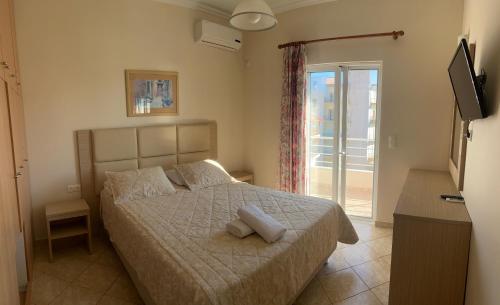 a bedroom with a bed and a sliding glass door at Lovely Anna's Apartments in Sarandë