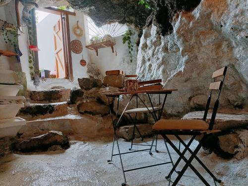 een kamer met een tafel en stoelen in een grot bij La Casita del acantilado in Puerto de la Madera