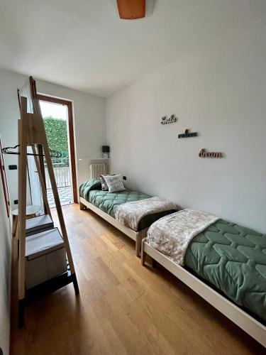 two beds sitting in a room with a ladder at Green Room Del Garda in Castelnuovo del Garda