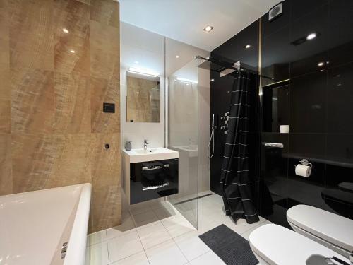 W łazience znajduje się wanna, umywalka i prysznic. w obiekcie Copernicus Dream Apartment Toruń Stare Miasto w Toruniu