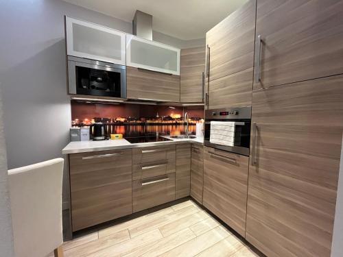 a kitchen with wooden cabinets and a counter top at Copernicus Dream Apartment Toruń Stare Miasto in Toruń