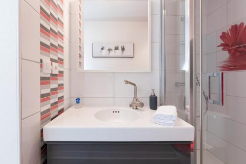 ein Badezimmer mit einem weißen Waschbecken und einer Dusche in der Unterkunft KER UHEL - Charmant appartement plein centre in Saint-Renan