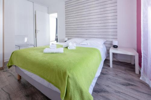 ein Schlafzimmer mit einem großen Bett und einer grünen Decke in der Unterkunft KER UHEL - Charmant appartement plein centre in Saint-Renan