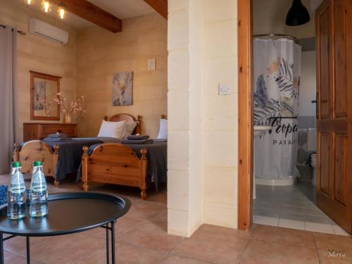 a room with two beds and a table at Moonshine Villa in Nadur