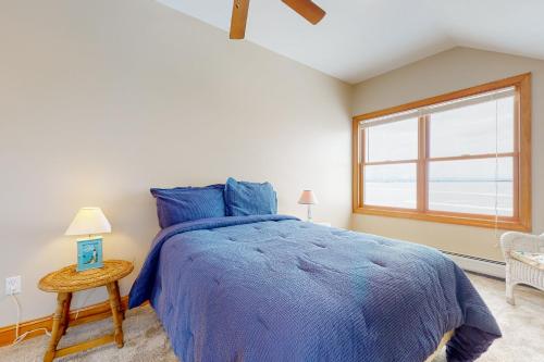 Un dormitorio con una cama azul y una ventana en Life on the Lake en Colchester