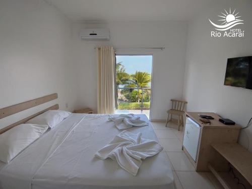 a bedroom with a bed and a desk and a window at Hotel Rio Acaraí in Camamu