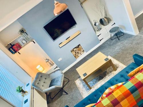 a living room with a blue couch and a table at Cosy home near Caerphilly 