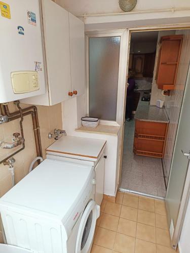 格拉納達的住宿－PISO EL SERRALLO，小厨房配有洗衣机。