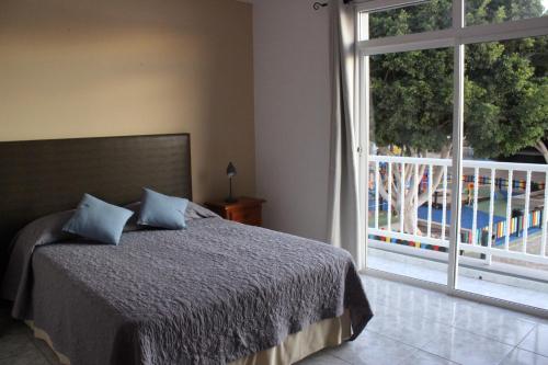 a bedroom with a bed and a large window at LA ORILLA BEACH HOUSE in La Lajita