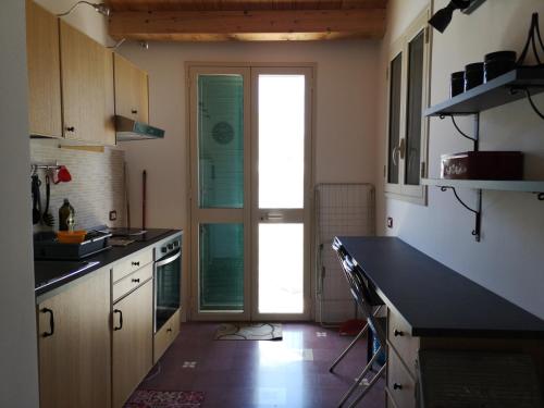 a kitchen with a black counter top and a glass door at Fichi e Gelsomino - Casa Vacanze in Donnalucata