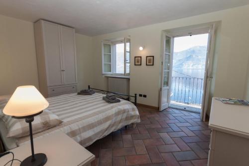 a bedroom with a bed and a balcony at Casa Pina in Menaggio