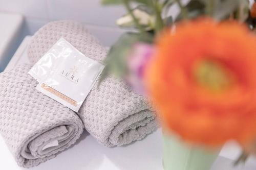 two towels on a table next to a vase of flowers at [Esclusivo Loano centro] mare a 50 mt + Wi-Fi in Loano