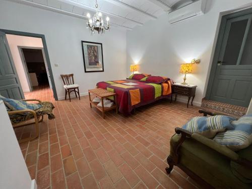 a bedroom with a bed and chairs in a room at Casa Rural Alzabara con Piscina Privada in Taberno