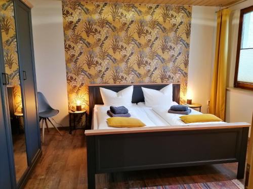 Schlafzimmer mit einem Bett mit weißer Bettwäsche und gelben Kissen in der Unterkunft Ferienhaus Altstadt in Naumburg