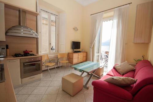 a living room with a red couch and a kitchen at Tremezzo Bella Vista by LoveComo in Tremezzo