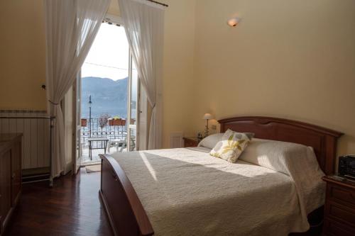 a bedroom with a bed and a large window at Tremezzo Bella Vista - lake front - lake view in Tremezzo